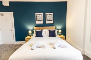 奥尔德姆Suite 2 - Comfy Spot in Oldham Sociable House的卧室配有白色大床和蓝色的墙壁