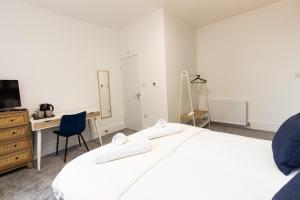 奥尔德姆Suite 2 - Comfy Spot in Oldham Sociable House的白色卧室配有书桌和床