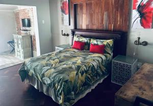 克龙斯塔德Lighthouse的一间卧室配有一张带木制床头板和红色枕头的床。