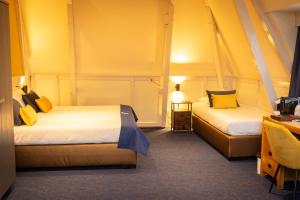 沃尔克姆金狮大酒店的黄色墙壁客房的两张床