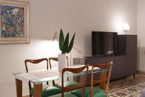 科拉托Amore Se Luxury Apartment的一间带桌椅和电视的用餐室