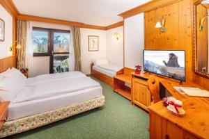 塞尔瓦迪卡多雷妮格丽泰拉酒店的配有一张床和一台平面电视的酒店客房