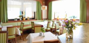 SchwanbergSchwanbergerstüberl的一间带桌椅和花瓶的餐厅