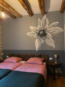 瓦拉洛Mountain Cabin Valsesia Appartement Stella的卧室的墙上挂着花卉壁画
