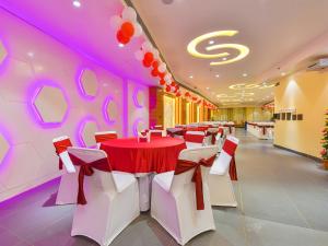 斋浦尔Hotel Anju Shree Inn的宴会厅配有红色和白色的桌椅