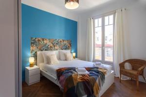 尼斯L1 Suite Auguste Valensin 10 min à pied Mer Clim&WIFI的一间卧室设有蓝色的墙壁和一张床