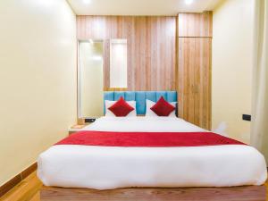 斋浦尔Hotel Anju Shree Inn的一间卧室配有一张带红色枕头的大床