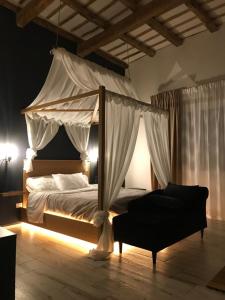 马尔萨拉Villa White Luxury Residence的一间卧室配有天蓬床和沙发