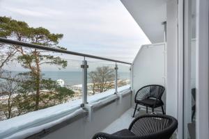 卢布明Hotel Seebrücke的阳台配有两把椅子,享有海滩美景