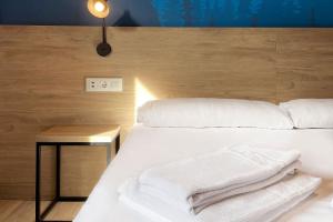 马萨纳Font Andorra Hostel的卧室配有白色的床和木制床头板