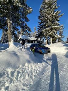 NordsetHytte til leie på Budor的停在房子前面的雪地里的汽车