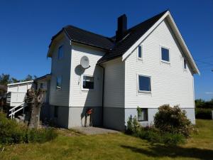奥勒松Haus auf der Insel Skuløya的黑色屋顶的大型白色房屋