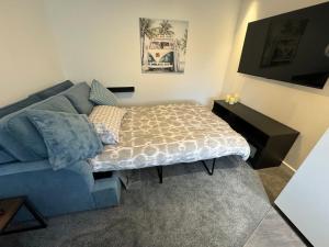 Bittonmodern 1 bed apartment with car parking的客厅配有床和蓝色沙发