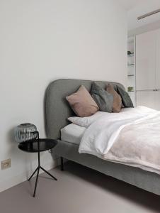 安特卫普Spacious and cosy apartment near Berchem Station的一间卧室配有一张带枕头和桌子的床
