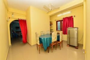 布莱尔港Pramod Bhawan , Port Blair的一间带桌椅和红色窗帘的用餐室