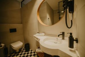 JõgevaCoop Hotell的一间带水槽、镜子和卫生间的浴室