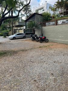 贝洛奥里藏特达奥尔拉潘姆普拉旅舍的两辆摩托车停在一栋楼旁边,一辆汽车