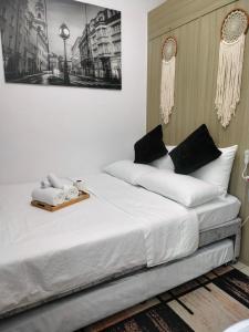 马尼拉Smdc Breeze Residence的一间卧室配有带白色床单和黑色枕头的床。