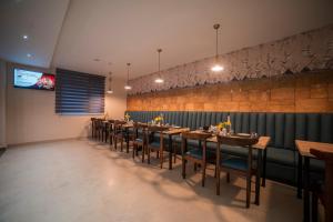 甘托克Zip By Spree Hotels Gangtok的一间带桌椅和电视的用餐室