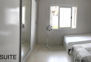 卡庞达卡诺阿Casa em Capao的白色的卧室设有床和窗户