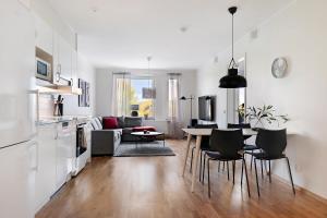博登Guestly Homes - 1BR Corporate Comfort的厨房以及带桌椅的起居室。