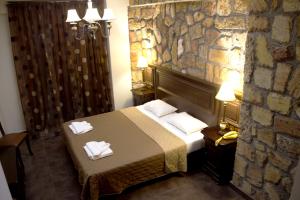 卢特拉艾季普苏Iris Spa的酒店客房,设有床铺和石墙