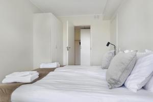 博登Guestly Homes - 1BR Corporate Comfort的一张白色大床,配有白色床单和枕头