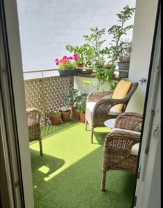 维也纳Rooms in Luxury Apartment, Central Vienna near Hauptbahnhof的阳台配有椅子和盆栽植物