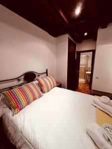 昆卡Rascacielos San Martín的卧室配有一张带彩色枕头的大型白色床。