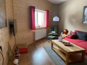 贝旺Aparthotels Berwang / Haus Wiesengrund的客厅配有红色的沙发和桌子