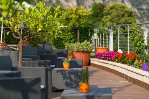 利莫内-苏尔加达Garda Suite Hotel的庭院里种有椅子和植物,鲜花盛开