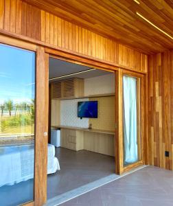 奥利文萨托罗罗姆芭度假酒店的客厅设有滑动玻璃门和电视