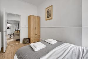 伦敦Lovely Kensington Apartments的白色卧室配有床和木柜