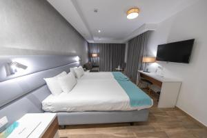 梅利哈索拉娜温泉酒店的酒店客房配有一张床、一张书桌和一台电视。
