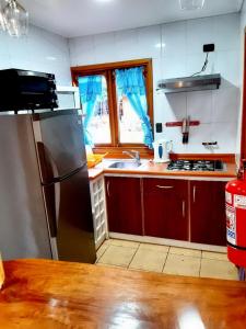 PucaráMapulauquen Cabañas的厨房配有不锈钢冰箱和水槽