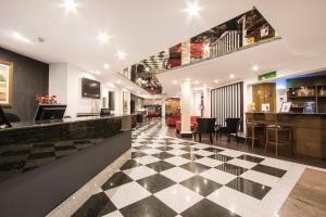 梅利哈佩尔格拉酒店&Spa的大堂设有格子地板和酒吧