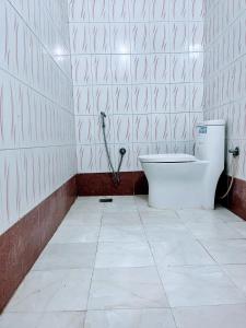 尼泊尔根杰Hotel Pahuna Ghar的瓷砖墙壁上设有带卫生间的浴室