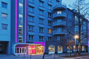 柏林柏林洪堡海因公园慕奇夕酒店的前面有粉红色灯光的蓝色建筑