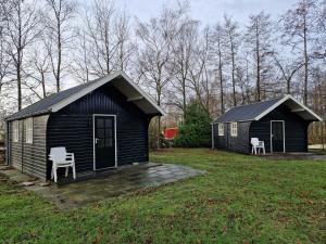 De ValomBlokhut camping De Zilveren Maan的院子内带两把椅子的小房子