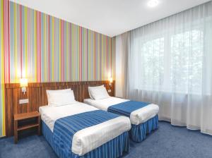 里加Rija VEF Hotel with FREE Parking的酒店客房设有两张床和窗户。
