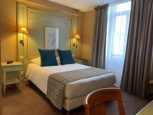 萨维尔纳Hôtel EUROPE的一间卧室配有一张带蓝色枕头的床和一扇窗户。