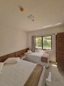 阿帕雷西达Hotel Mãe Morena的一间卧室设有两张床和窗户。