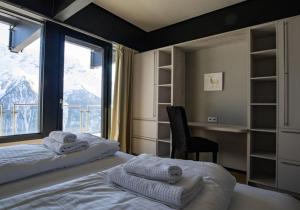 WilerLauchernalp Resort Residences的一间卧室配有一张床、一张书桌和一个窗户。