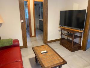 莱萨卡Magdalenea - Apartamento的一间带电视和红色沙发的客厅