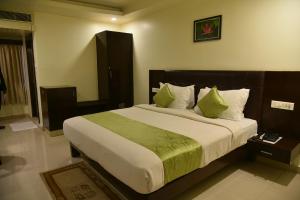 维沙卡帕特南Hotel green apple的卧室配有一张带绿床单和枕头的大床。