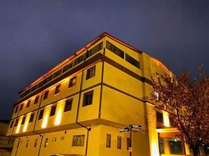 安卡拉Animos Butik Otel的上面有灯的黄色建筑