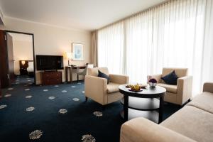 施塔恩贝格施塔恩贝格维尔四季酒店的酒店客房设有沙发、椅子和电视。