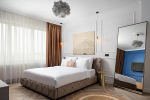 克卢日-纳波卡Siesta Boutique Smart Suites的一间带大床和电视的卧室