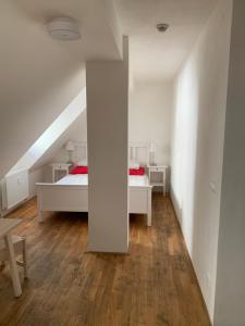 布尔诺Mitte Apartments的一间白色卧室,配有两张床和楼梯