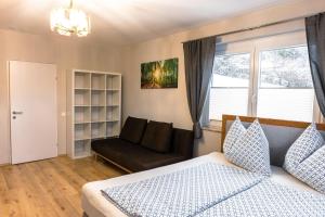 滨湖科伊查赫Real Top 1的一间卧室配有一张床、一张沙发和一个窗口